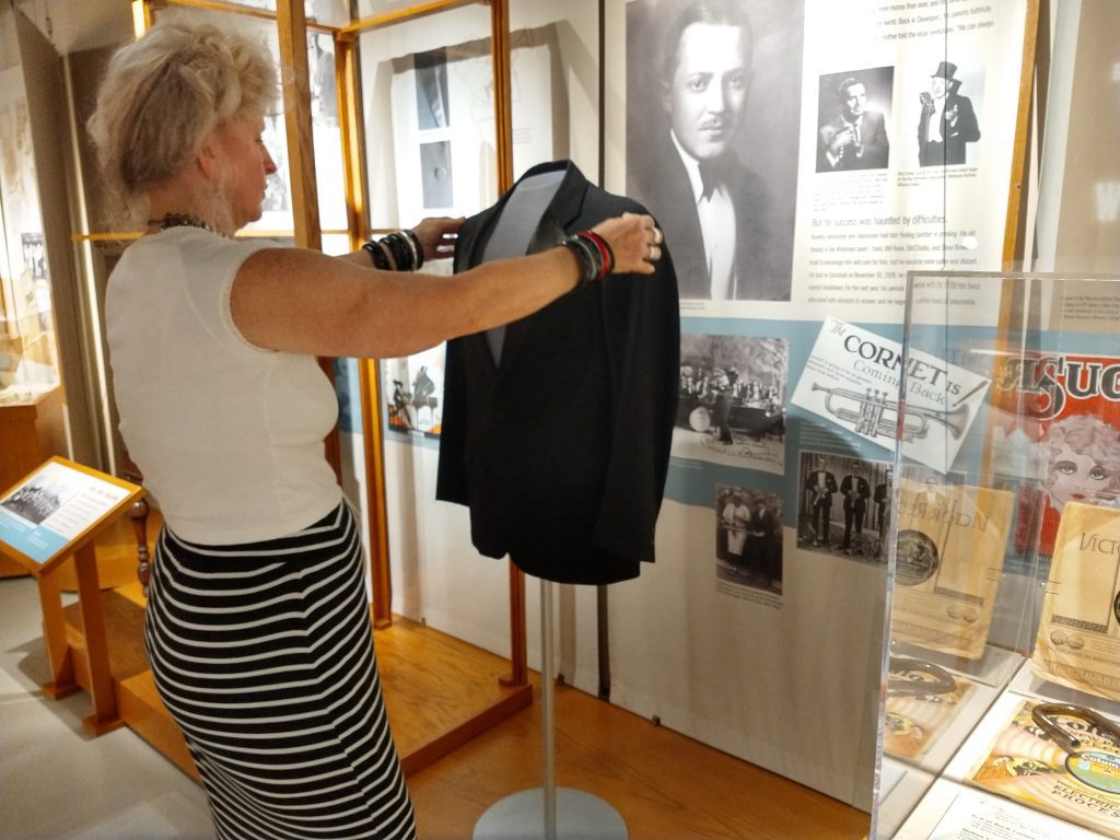 Laura Heath of Trash Can Annie's Vintage Clothing helps prepare the Bix tuxedo as a new display in the Bix Museum.